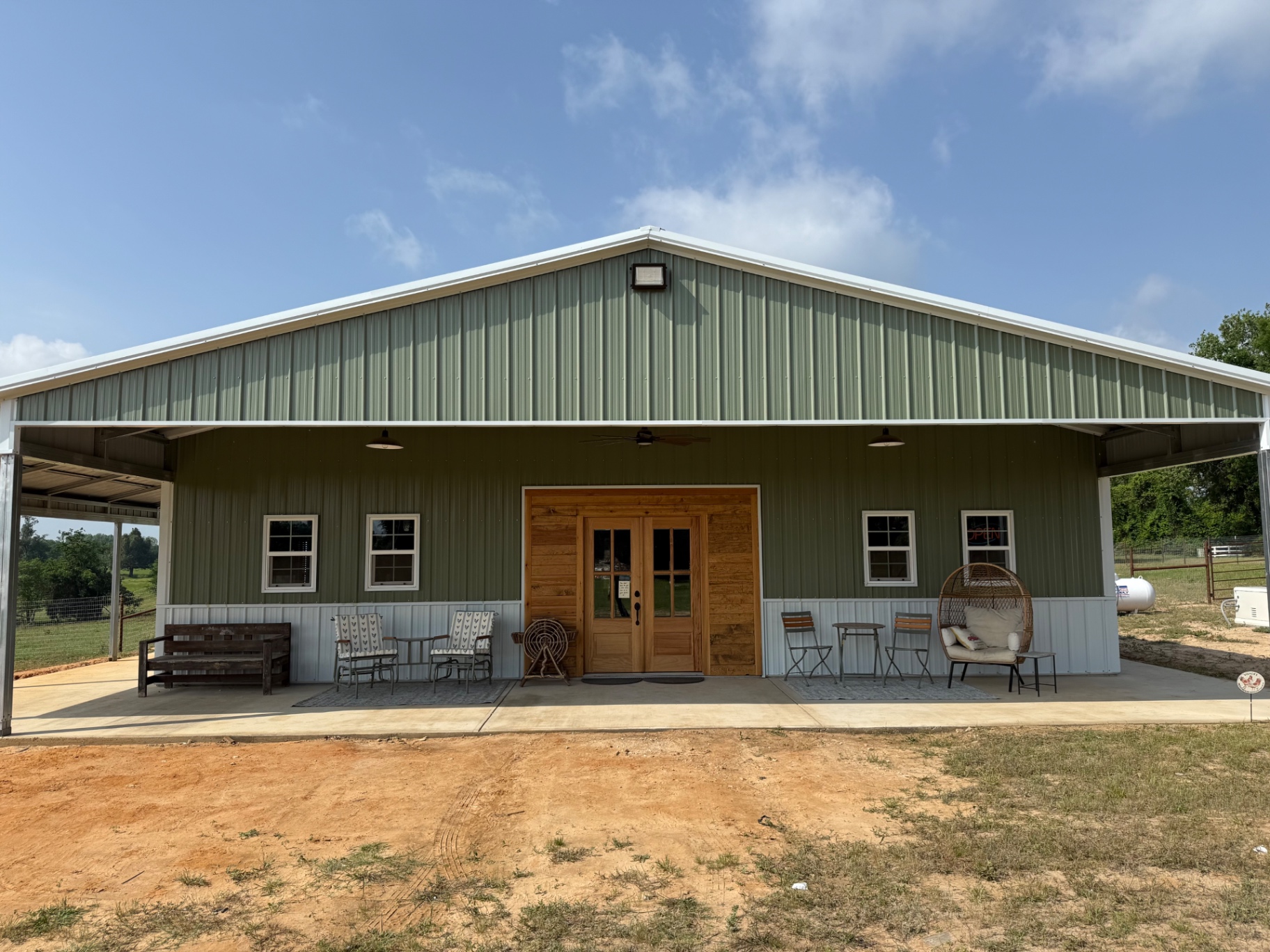 The Little Braveheart Farms shop — a green-and-white barn-style building with a wide covered porch in Lindale, Texas